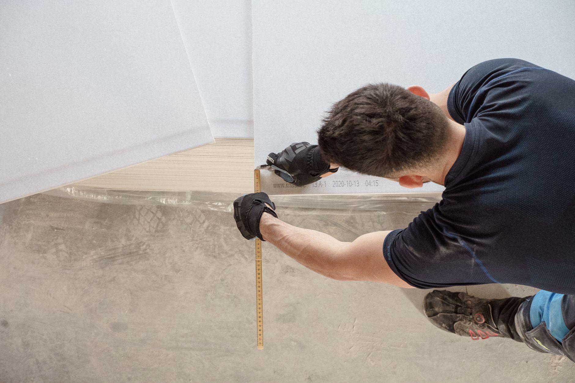 Construction worker measuring and cutting flooring panels in a renovation project in Riverside, CA